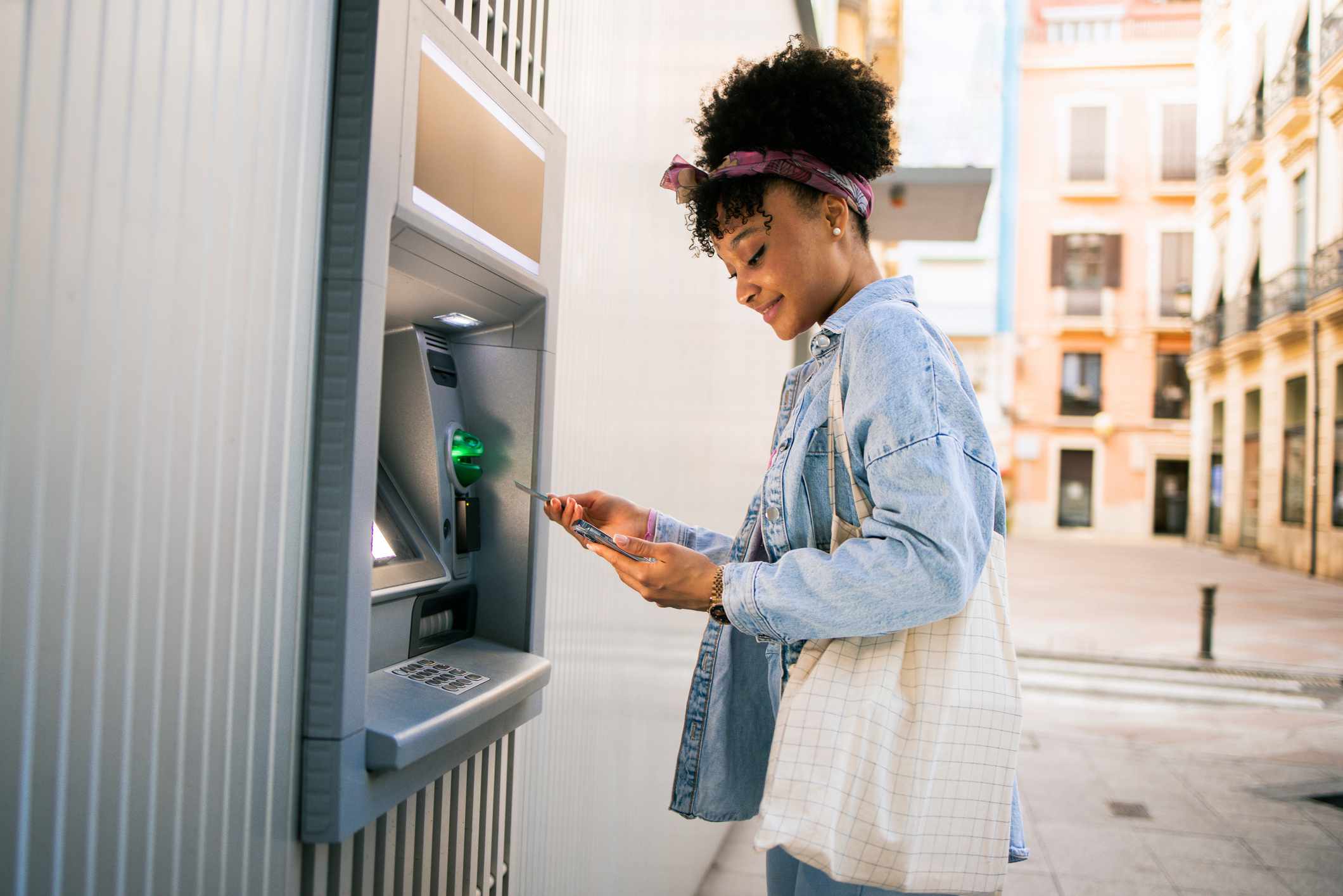 A woman makes an ATM withdrawal.