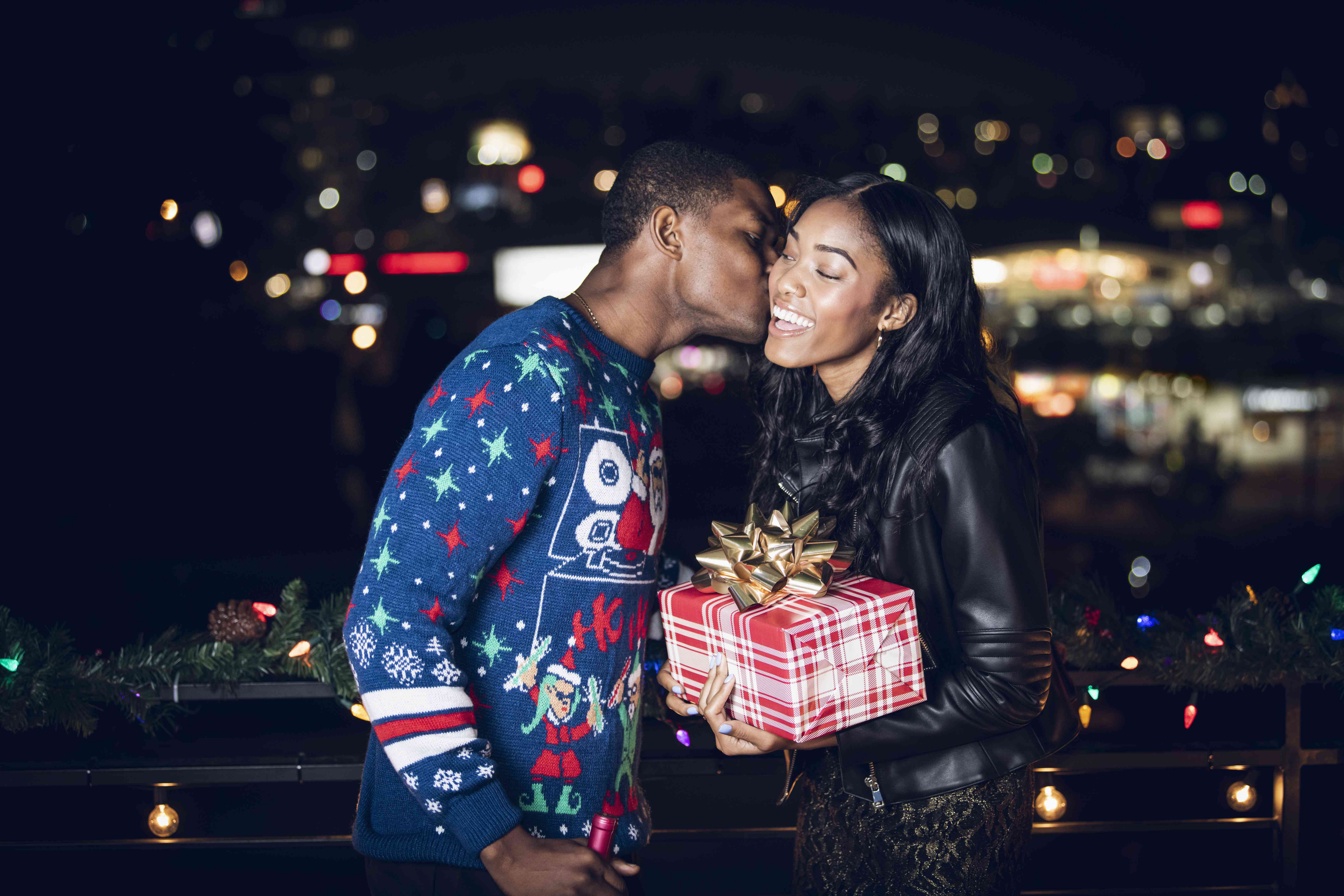 A woman accepting a present and kiss from a male friend