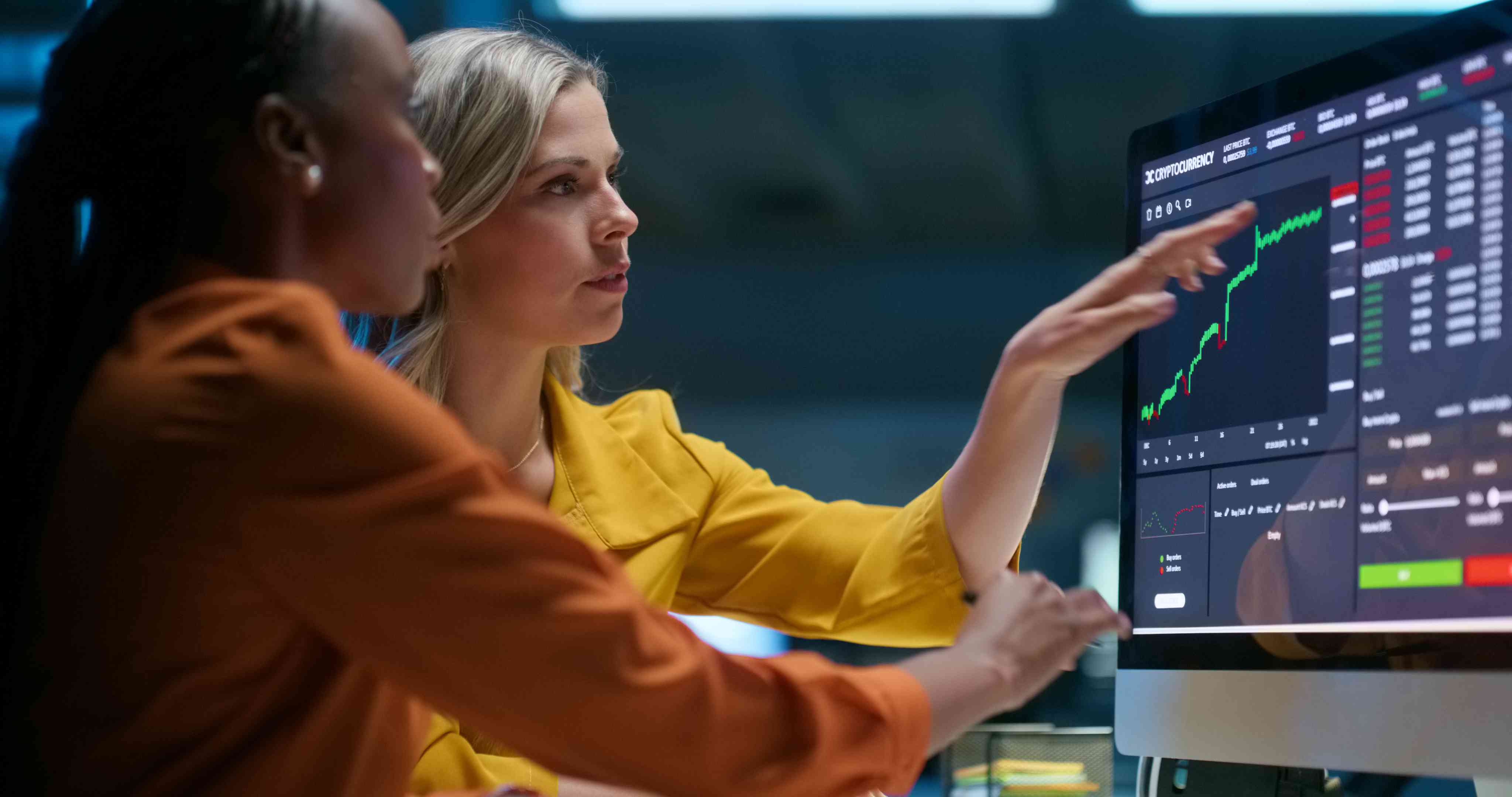 Business people looking at a computer screen with stock market information.