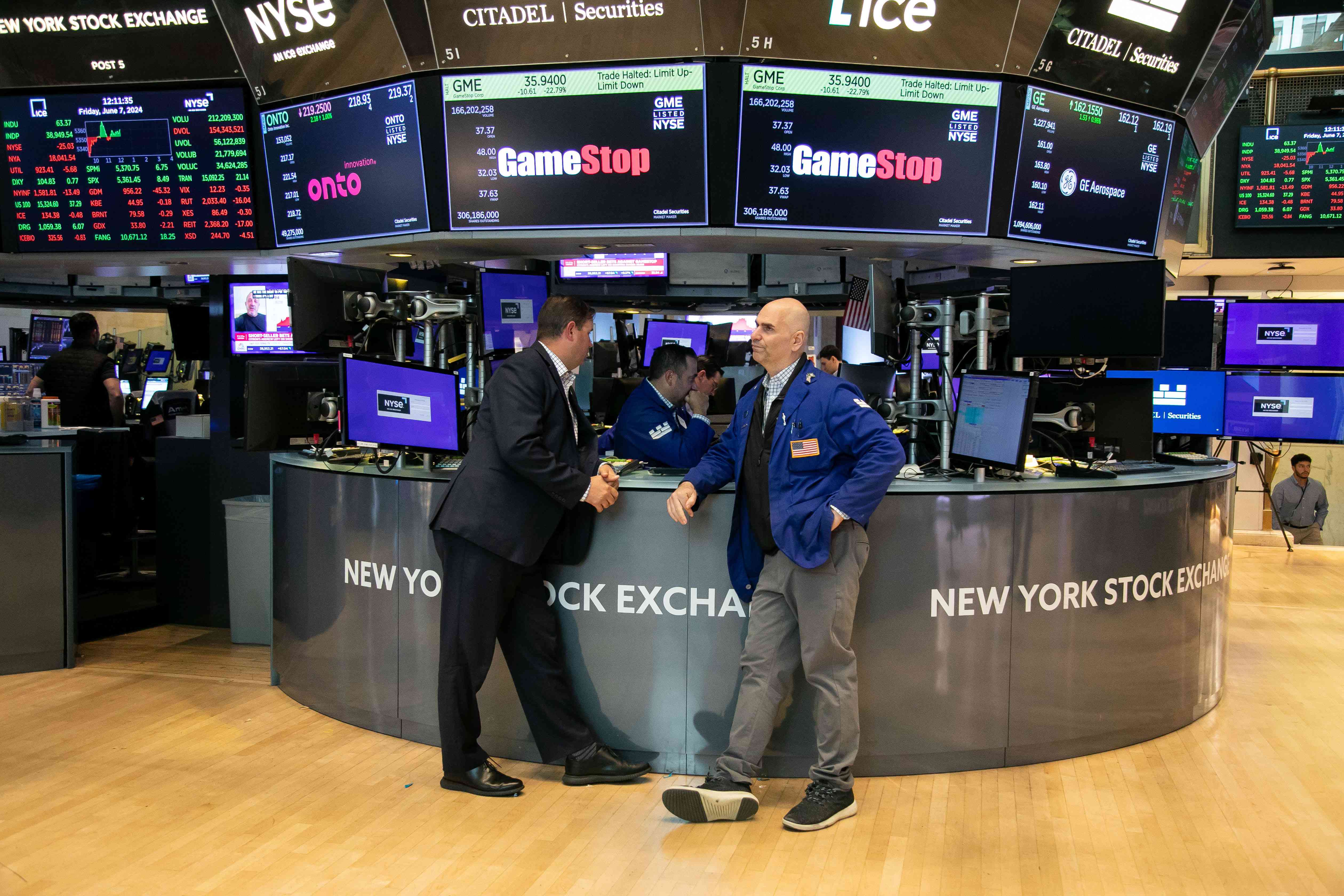 Traders on the floor of the NYSE standing in front of a GameStop ticker