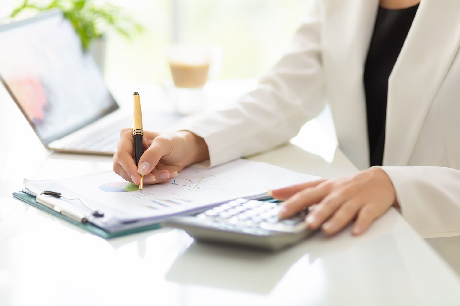 Businessperson working with laptop, calculator, and business documents