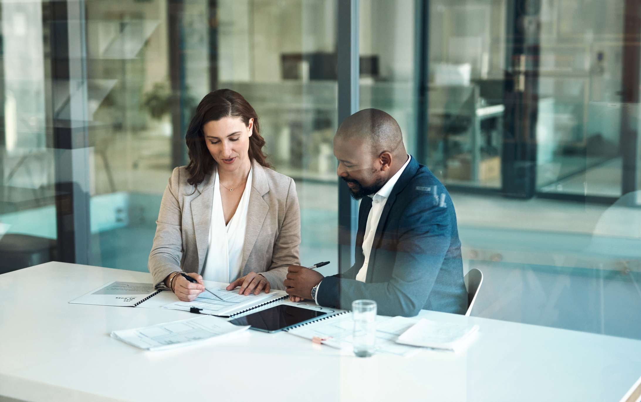 Two professionals review documents in an office.