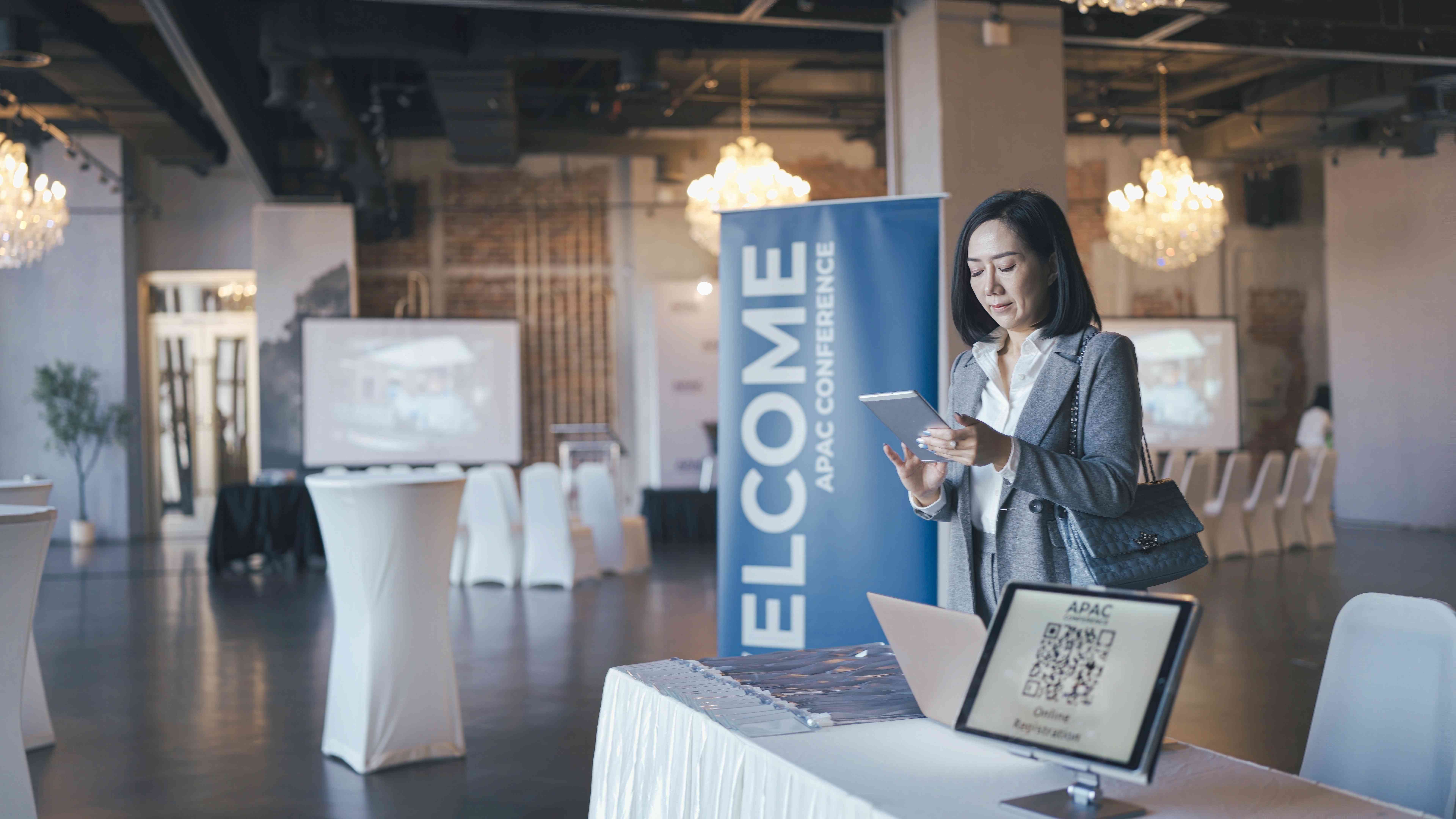 A receptionist at the welcome desk for an annual shareholders meeting looks at a pad listing shareholders registered to attend.