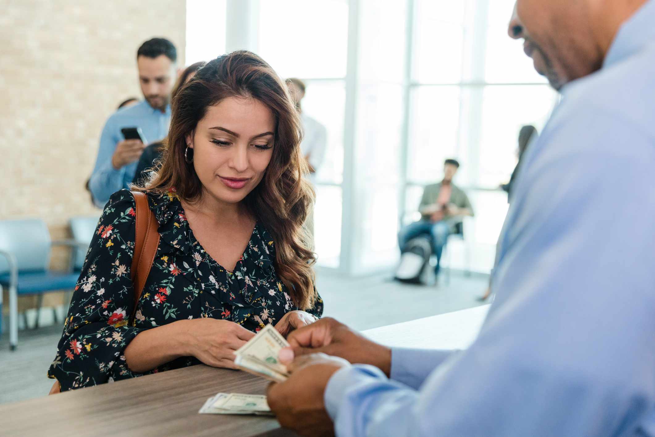 A woman gets money from a teller.